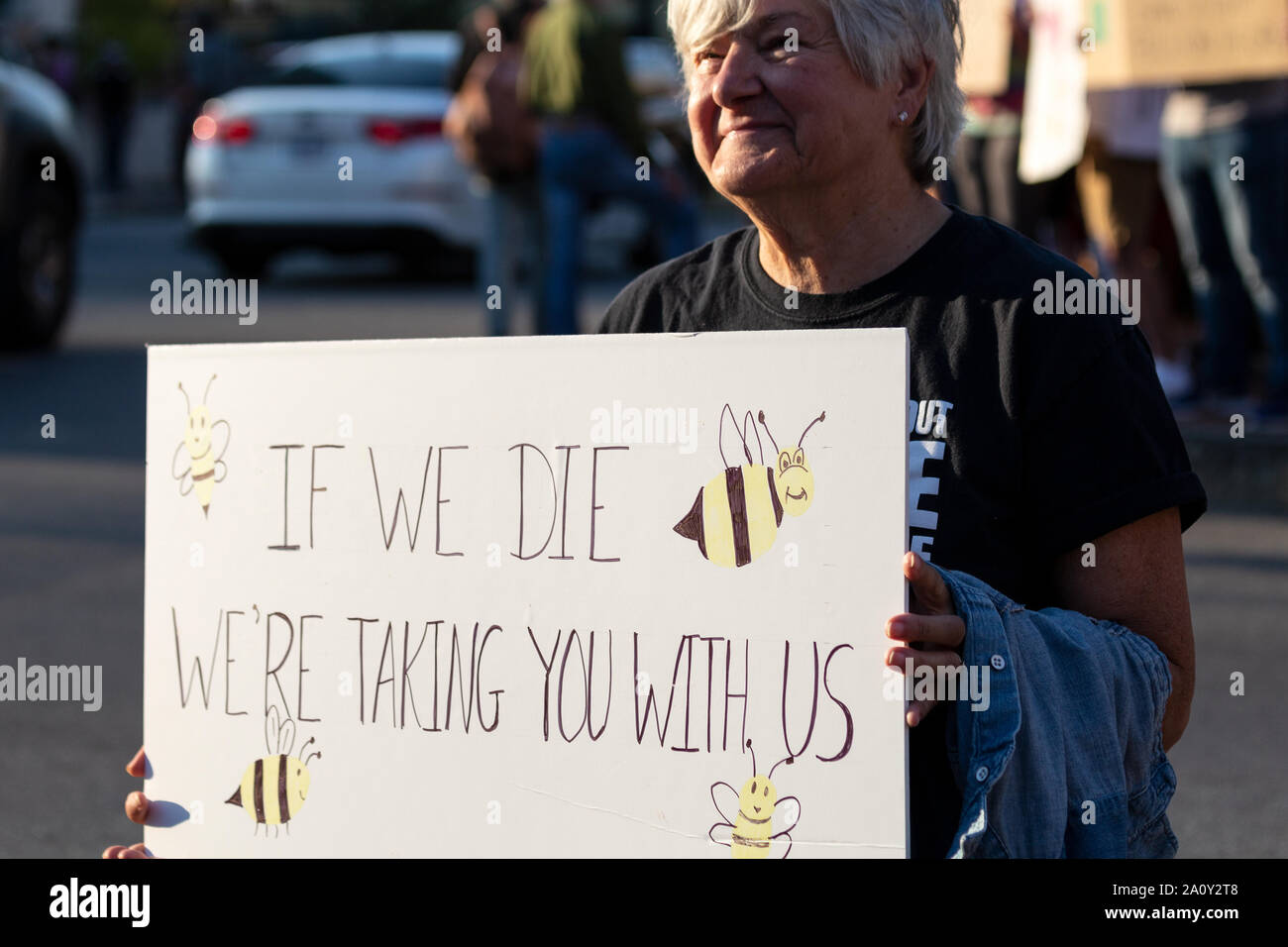 Eine ältere Frau hält ein Schild bei der International Climate Justice Rally in Asheville, NC, USA Stockfoto