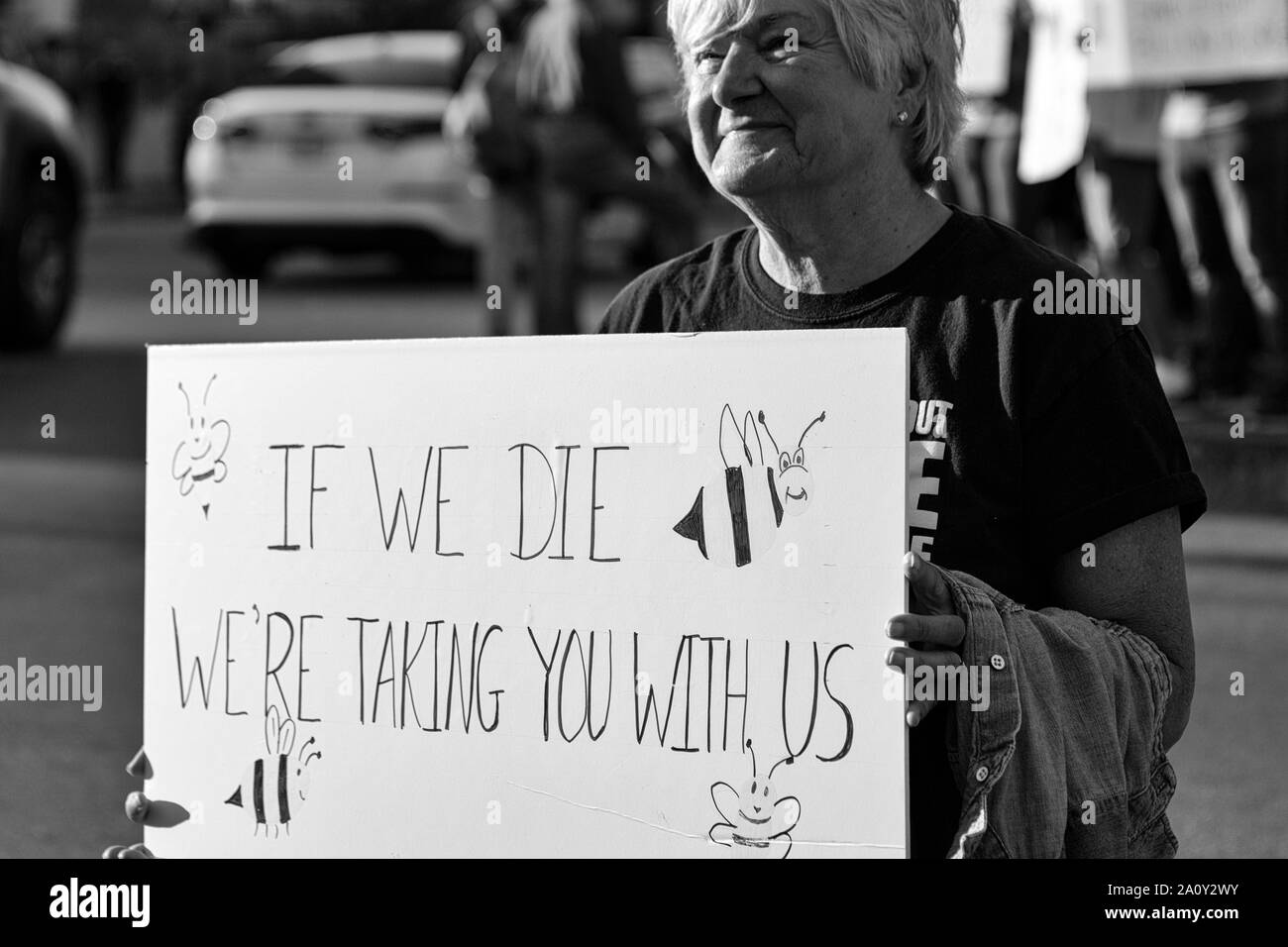 Eine ältere Frau hält ein Schild bei der International Climate Justice Rally in Asheville, NC, USA Stockfoto