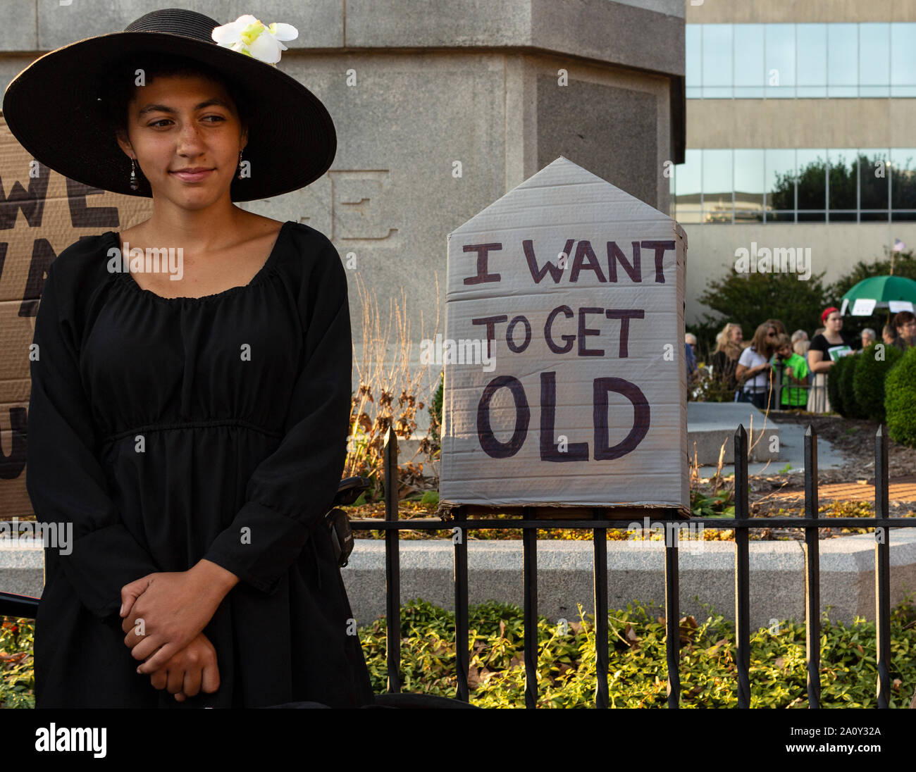 Ein junger Demonstrant steht neben ihr Zeichen, auf internationaler Klimagerechtigkeit Rallye in Asheville, NC, USA Stockfoto