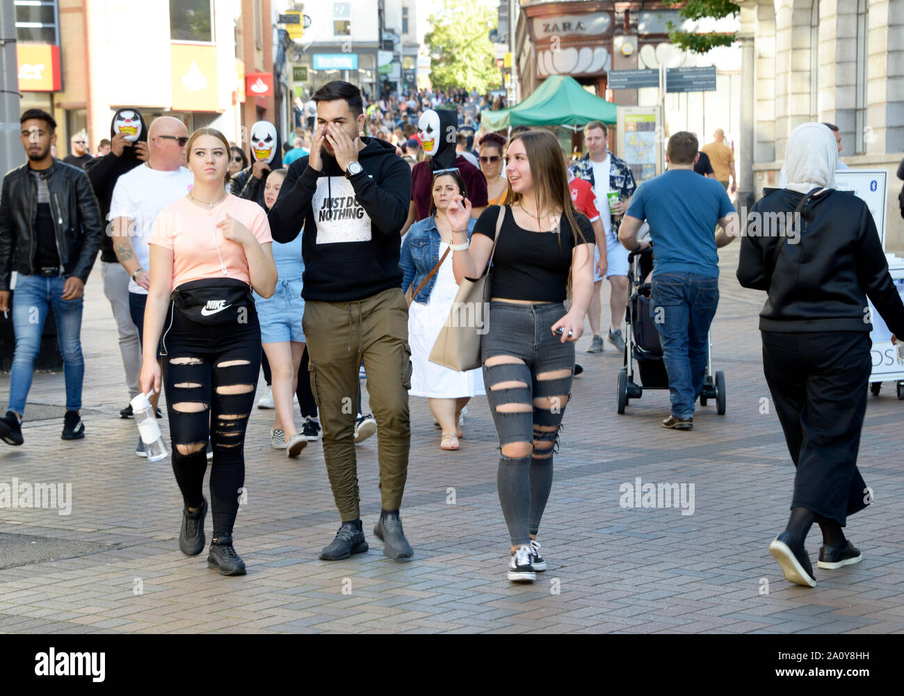 Guy & zwei Mädchen, zerrissene Jeans, Einkaufen. Stockfoto