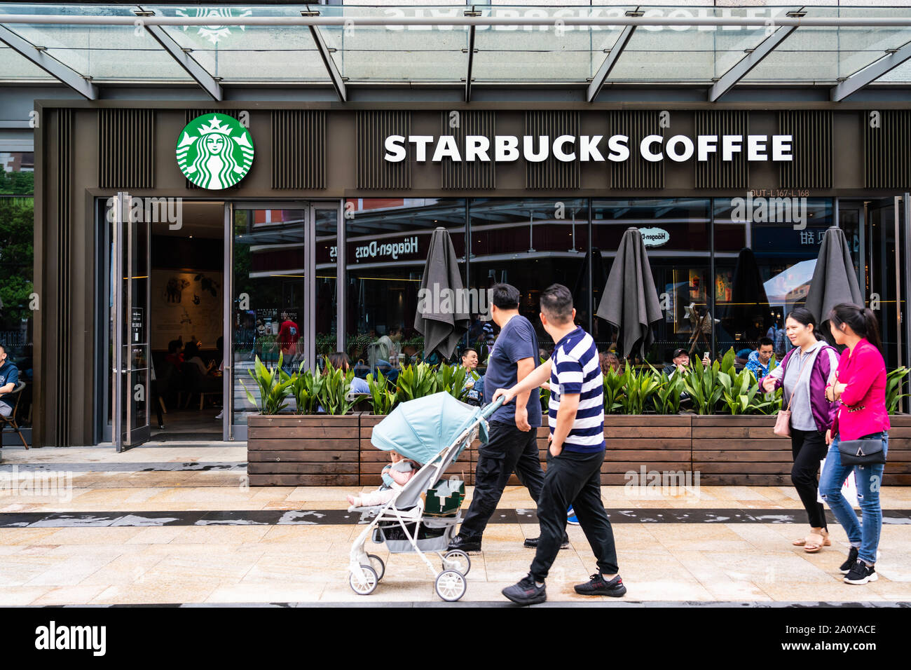 Fußgänger vorbei an einem Starbucks Stores in Shanghai. Ein amerikanischer Kaffee und Kaffeehaus Kette. Stockfoto
