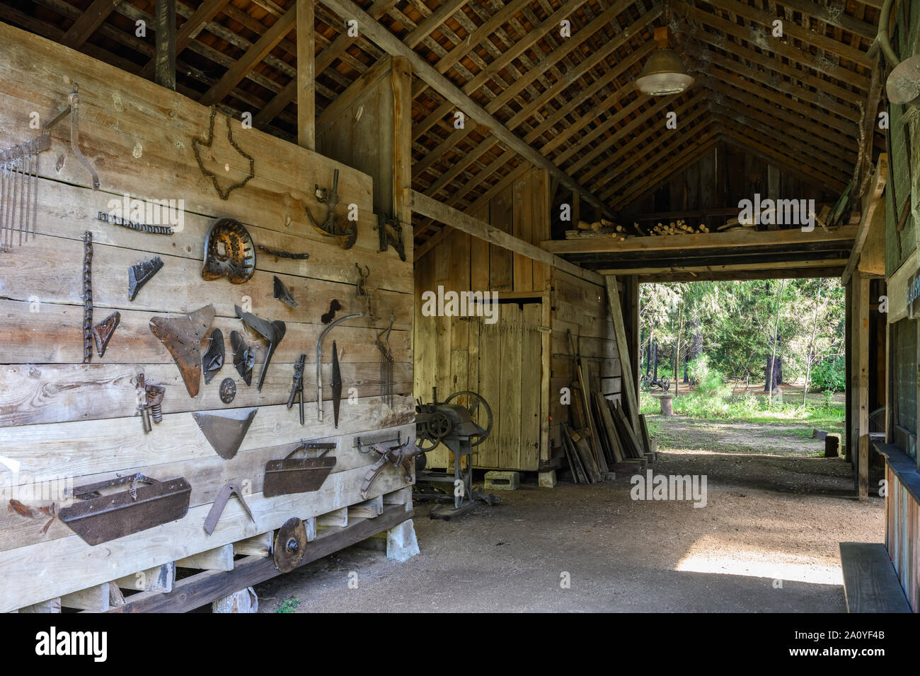 Landwirtschaftliche Werkzeuge an die Wand einer alten Schmiede an Kleb Holz Natur Park erhalten. Houston, Texas, USA. Stockfoto