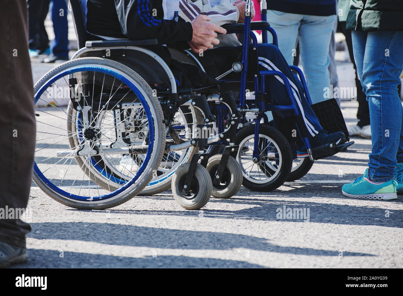 Rollstuhl Räder closeup auf Asphalt. Das Konzept der sozialen Gleichheit, Schutz und Unterstützung der Menschen mit Behinderungen Stockfoto