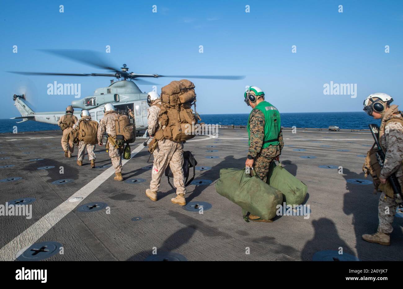 190919-N-HD 110-1197 Arabische Meer (bis 30. 19, 2019) Marines gehen Sie in Richtung einer UH-1Y Venom Hubschrauber an Marine Medium Tiltrotor Squadron (VMM) 163 (verstärkt), auf dem Flugdeck des Amphibischen dock Landung Schiff USS Harpers Ferry (LSD 49). Harpers Ferry ist Teil der Boxer Amphibious Ready Gruppe und 11 Marine Expeditionary Unit und ist in die USA 5 Flotte Bereich der Maßnahmen zur Unterstützung der Marine im Einsatz für die Stabilität und Sicherheit in der Region zu gewährleisten und verbindet das Mittelmeer und den Pazifischen Raum durch den Westlichen Indischen Ozean und drei strategische Choke po Stockfoto