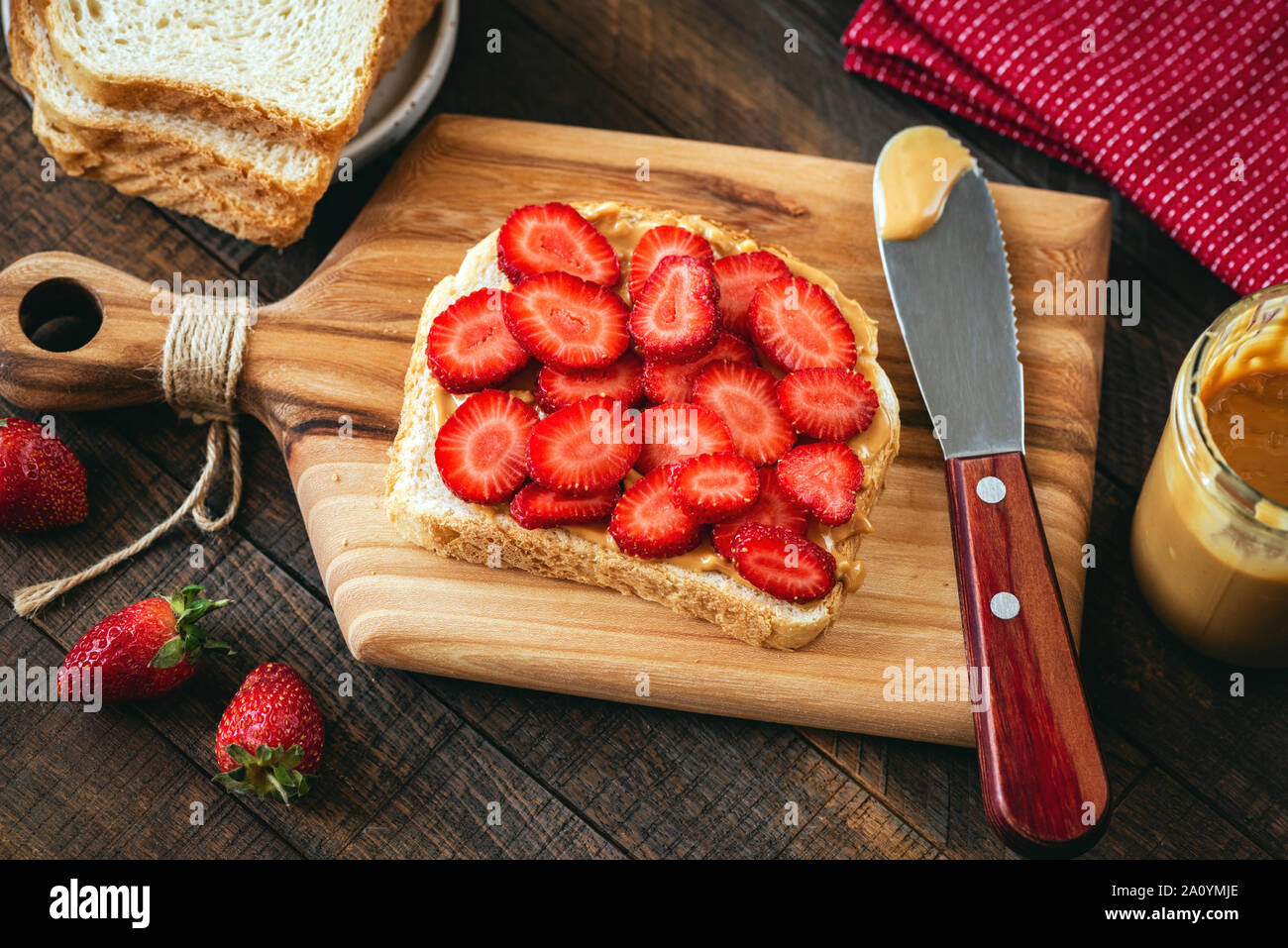 Peanut Butter und Erdbeere Toast auf einem hölzernen Schneidebrett. Gesundes Frühstück oder Mittagessen Sandwich Stockfoto
