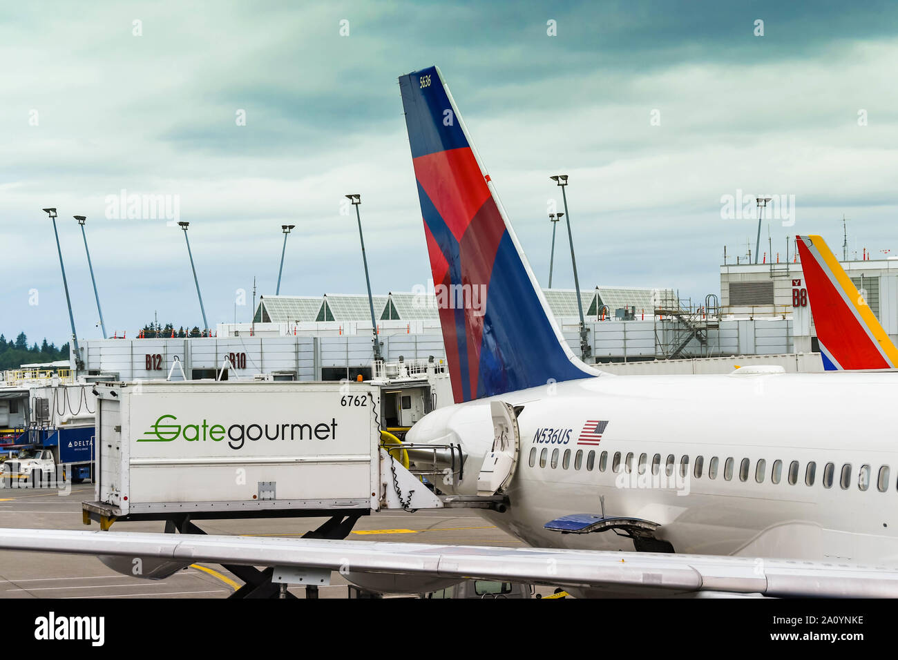 Seattle TACOMA AIRPORT, WA, USA - JUNI 2018: Gate Gourmet Hydrauliklaufwagen beladen Lebensmittel und andere Catering-Materialien auf einen Delta Airlines Jet Stockfoto