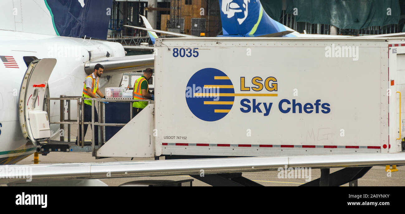 Seattle TACOMA AIRPORT, WA, USA - JUNI 2018: Nahaufnahme der Flughafenmitarbeiter, die Lebensmittel und Catering-Materialien von einem Hubwagen von "rächen" von "Sky Chefs" laden Stockfoto