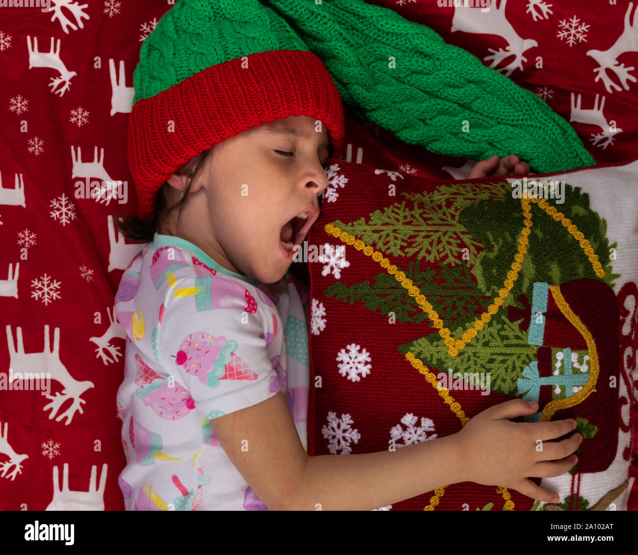 Gähnen Mädchen zu Hause an Weihnachten mit großen Teddybär Plüsch Spielzeug. Neues Jahr Winterurlaub Konzept. Stockfoto
