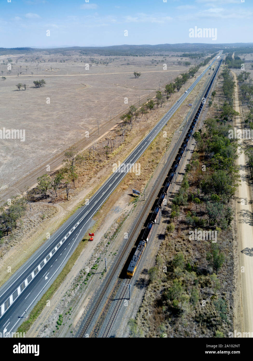 Antenne von Kohle Zug entlang der Seite des Bruce Highway nach Gladstone export Klemmen und der Station Queensland Australien Stockfoto