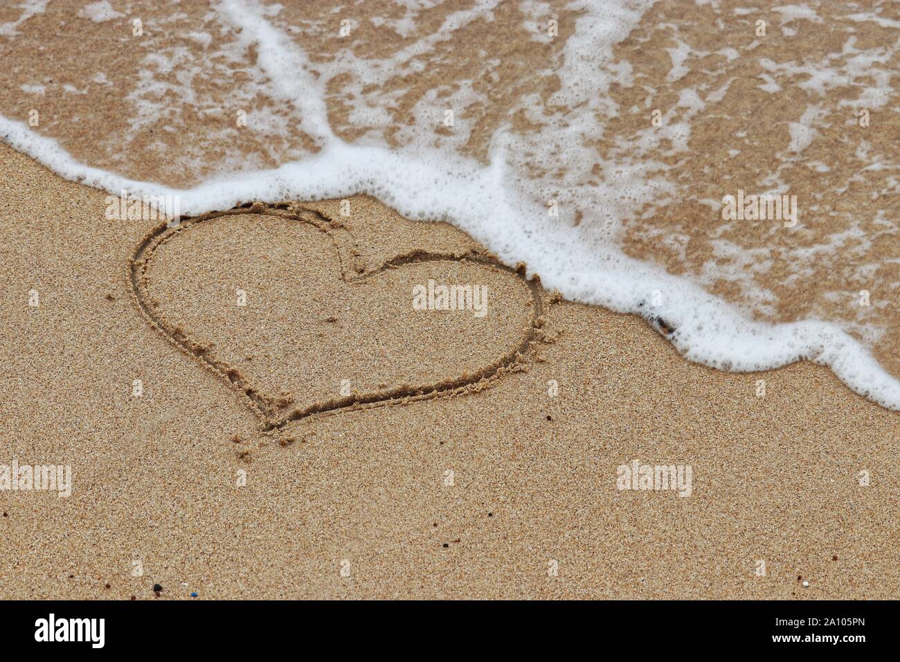 Herzform an einem Sandstrand und eingehende sea wave. Das Konzept der flüchtige Liebe, Romantik, romantische Reisen Urlaub Stockfoto
