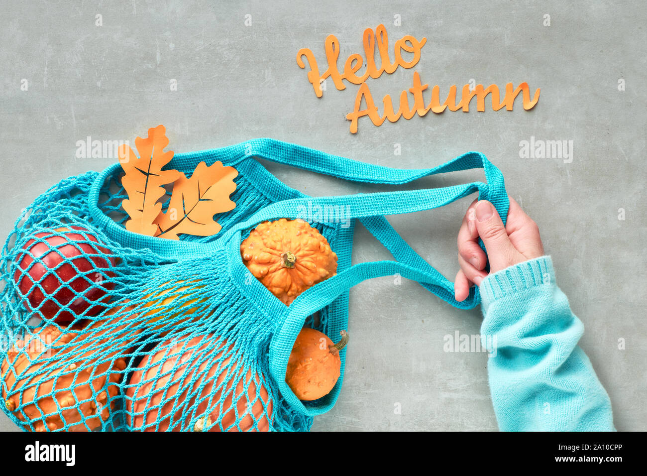 Herbst flach mit Türkis string Tasche mit orange Kürbisse, top vie am grauen Stein Hintergrund Stockfoto