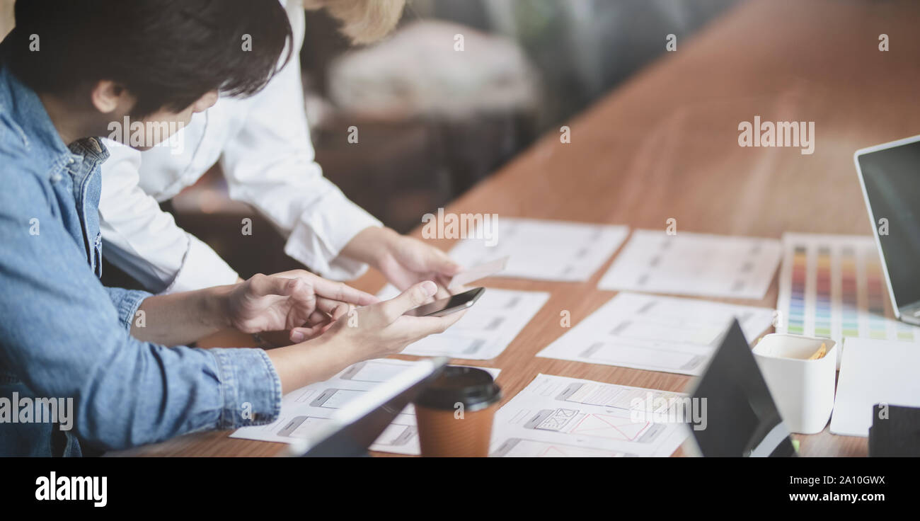 7/8-Ansicht von UI-Designer Hobeln der UX-Anwendungsentwicklung mit Teammitgliedern in modernen Arbeitsplatz Stockfoto