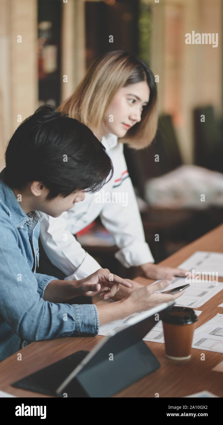 7/8-Ansicht von UI-Designer Hobeln der UX-Anwendungsentwicklung mit Teammitgliedern in modernen Arbeitsplatz Stockfoto