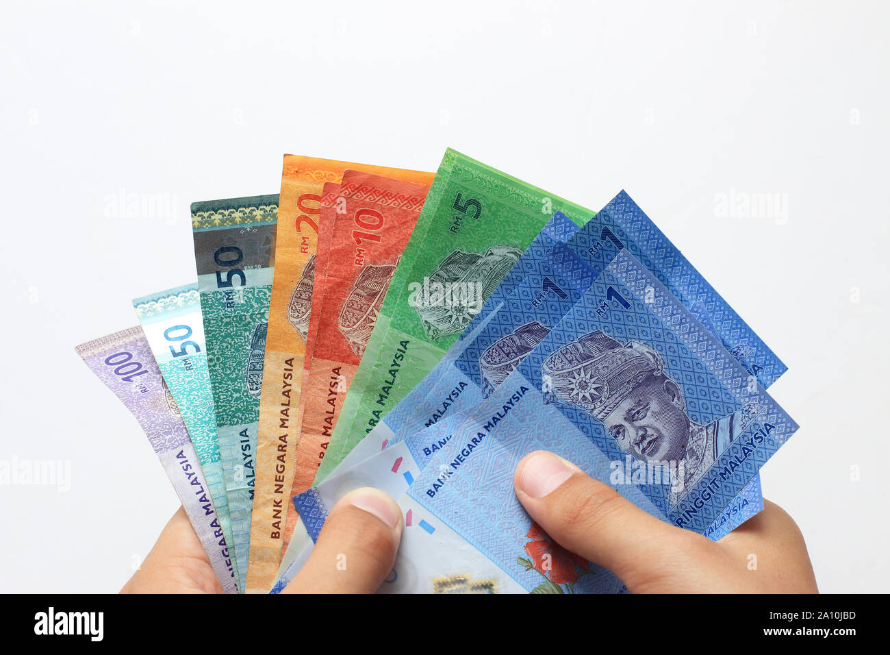 Hand, die eine Mischung aus malaysische Währung in Notizen vor weißem Hintergrund Stockfoto