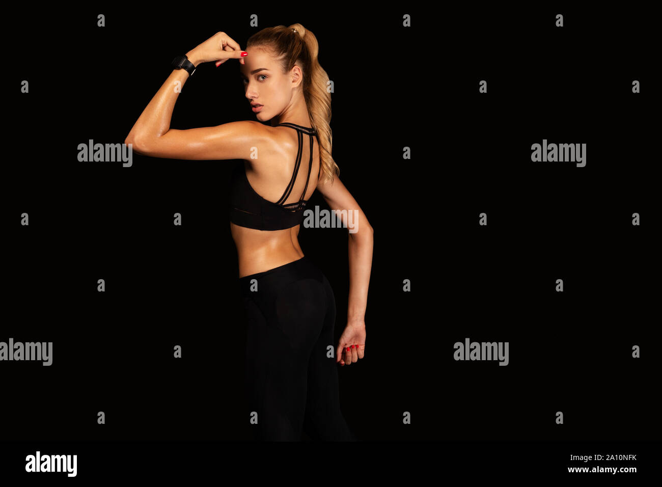 Passen Mädchen zeigen Armmuskeln posiert auf schwarzem Hintergrund Stockfoto