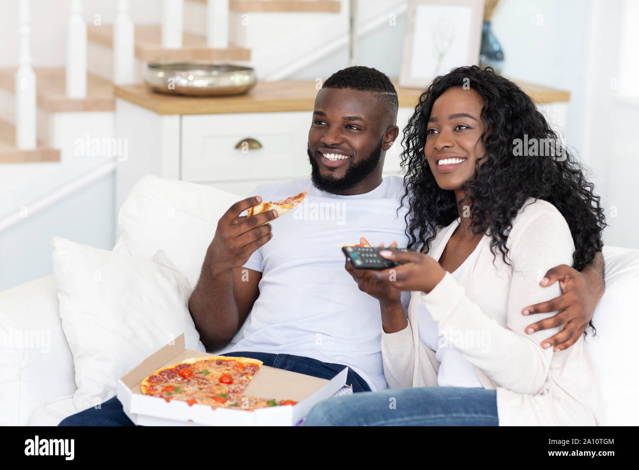 African American Ehegatten essen Pizza und Fernsehen zu Hause Stockfoto