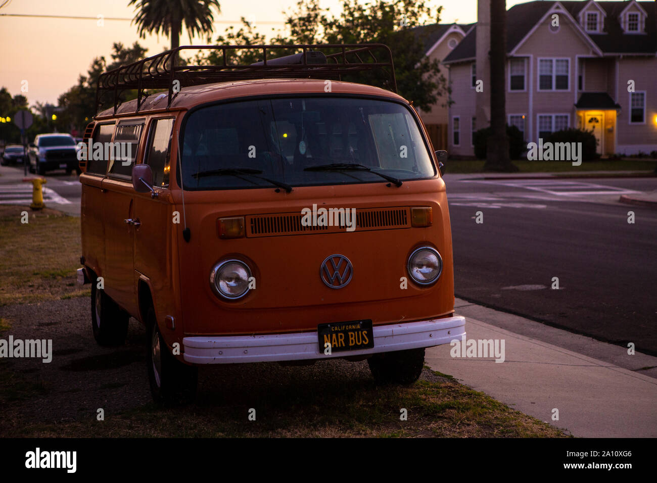Ein VW-Bus T2 Oldtimer in Santa Barbara in Kalifornien in der Abendsonne. Der Bulli in Orange mit Dachgepäckträger in Originalzustand konnte dank des Stockfoto