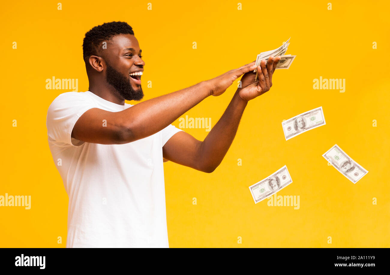 Happy african american Kerl heraus werfen Geld Banknoten Stockfoto
