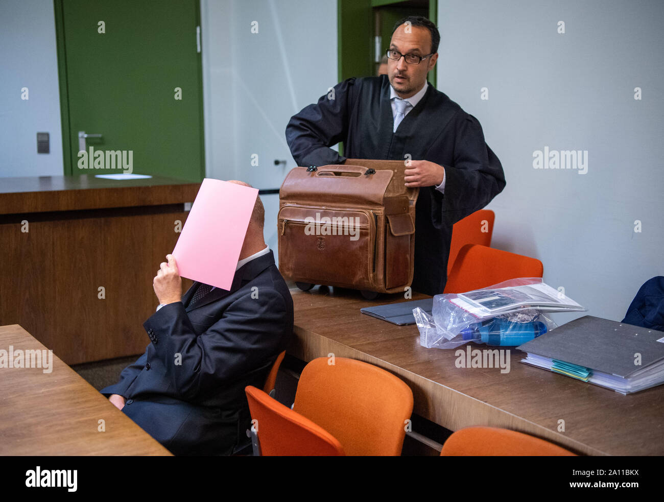 München, Deutschland. 23 Sep, 2019. Die Beklagte des versuchten Totschlags sitzt im Dock, während sein Rechtsanwalt Adam Ahmed (r) entpackt Dokumente. Der Vater der Familie ist, versucht haben, seine Familie zu töten und sich dann selbst. Seine Frau, Tochter und Sohn überlebte, einige von ihnen schwer verletzt. Credit: Lino Mirgeler/dpa/Alamy leben Nachrichten Stockfoto