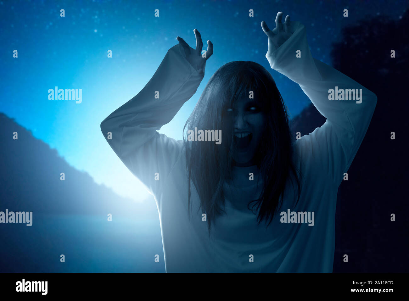 Beängstigend ghost Frau mit Blut und wütend das Gesicht mit den Händen kratzt stehend mit moonlight Hintergrund. Halloween Konzept Stockfoto