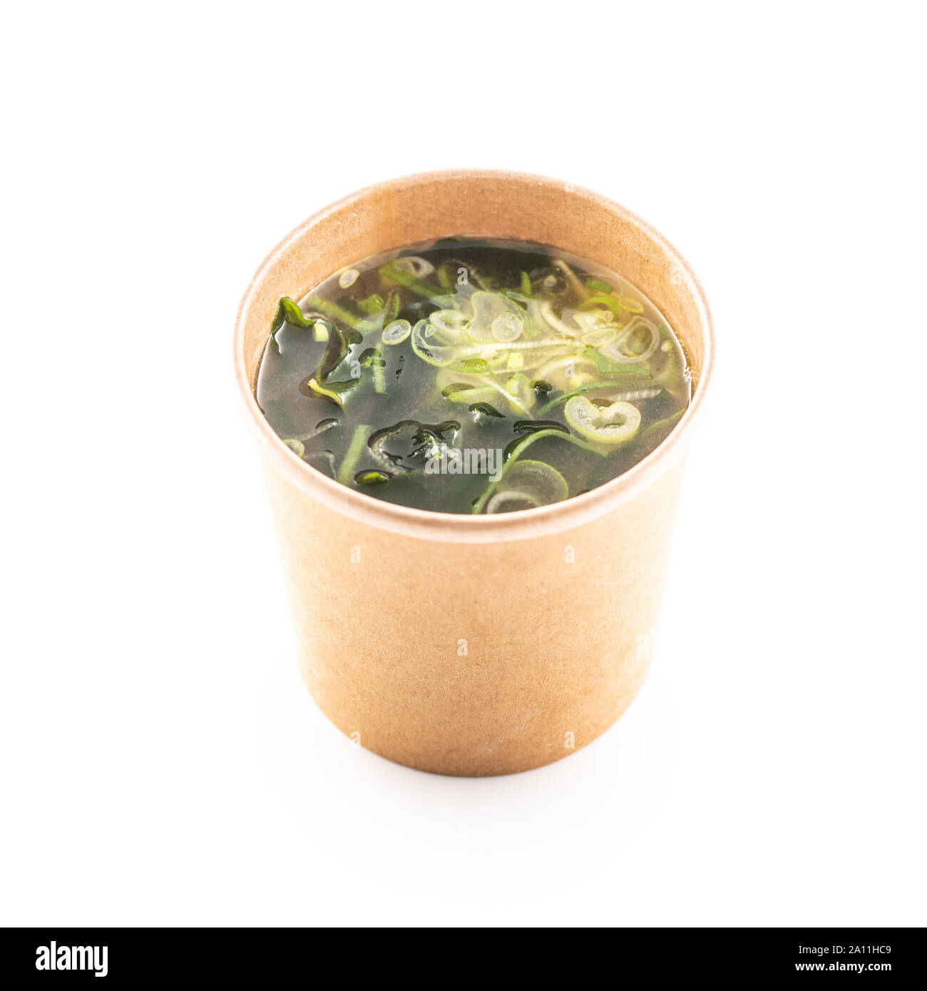 Japanische asiatische Suppe miso in eine Schale von Recyclingpapier auf weißem Hintergrund. Stockfoto