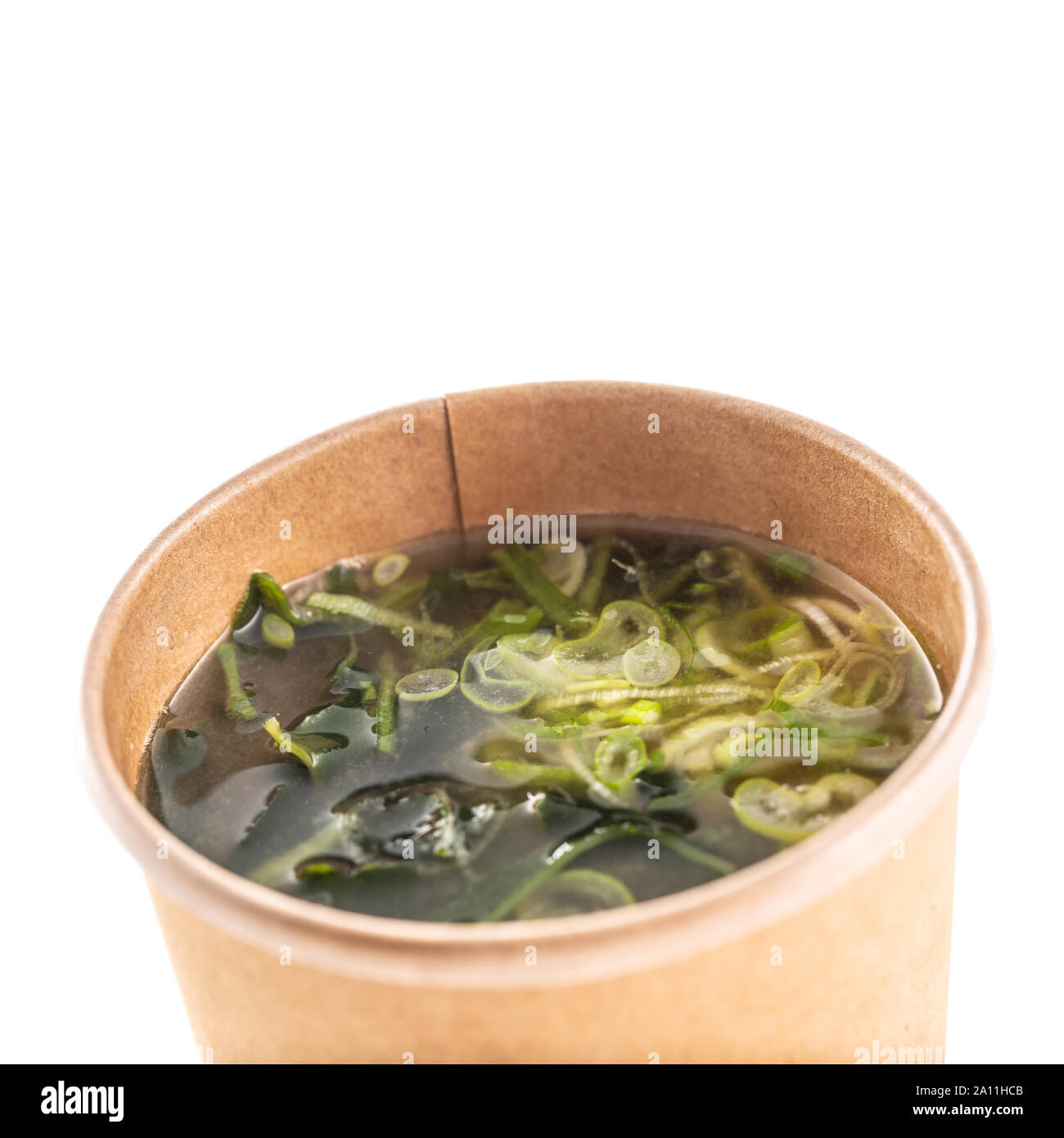 Japanische asiatische Suppe miso in eine Schale von Recyclingpapier auf weißem Hintergrund. Stockfoto