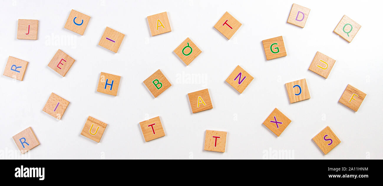 Zerstreute Buchstaben des Alphabets Holzklötze Fliesen auf weißem Hintergrund. Ansicht von oben Stockfoto