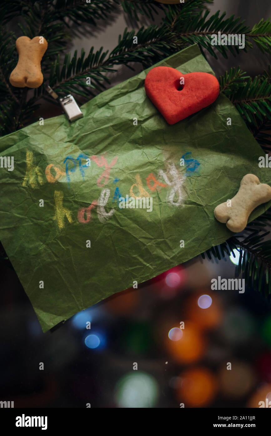 Grünbuch mit einem glücklichen Urlaub auf es am Weihnachtsbaum zusammen mit Hund angespannt geschrieben behandelt Stockfoto