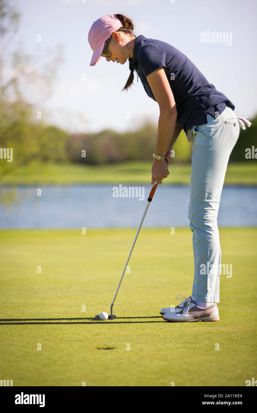 Weibliche Golf Spieler setzen auf Grün. Stockfoto