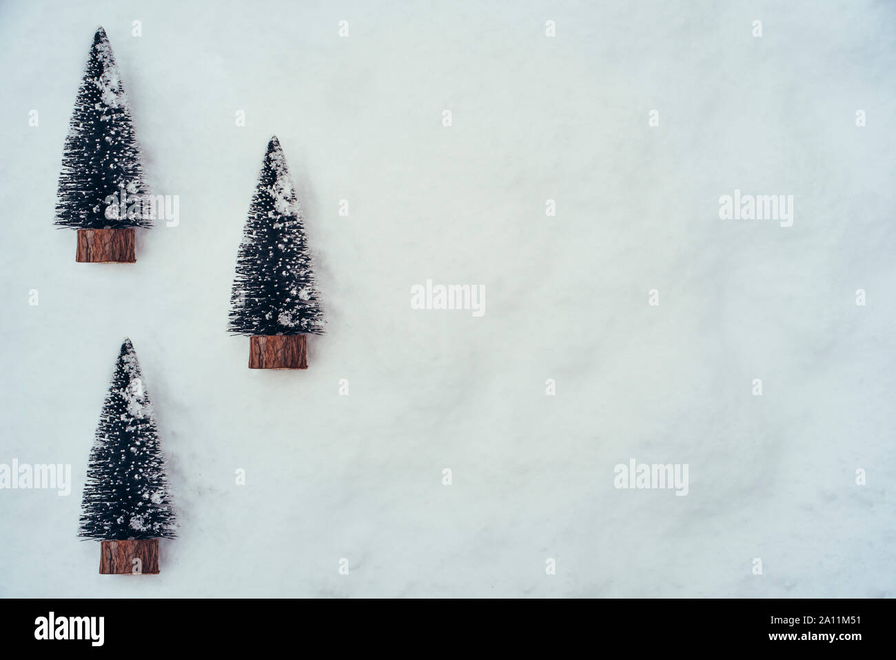 Drei kleine künstliche Weihnachtsbäume im Schnee Stockfoto