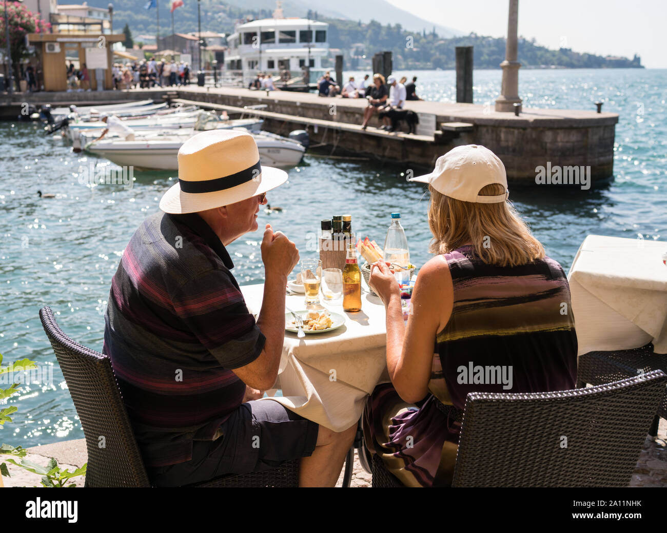 Paar beim Mittagessen unter den Arkaden von Malcesine marina Stockfoto