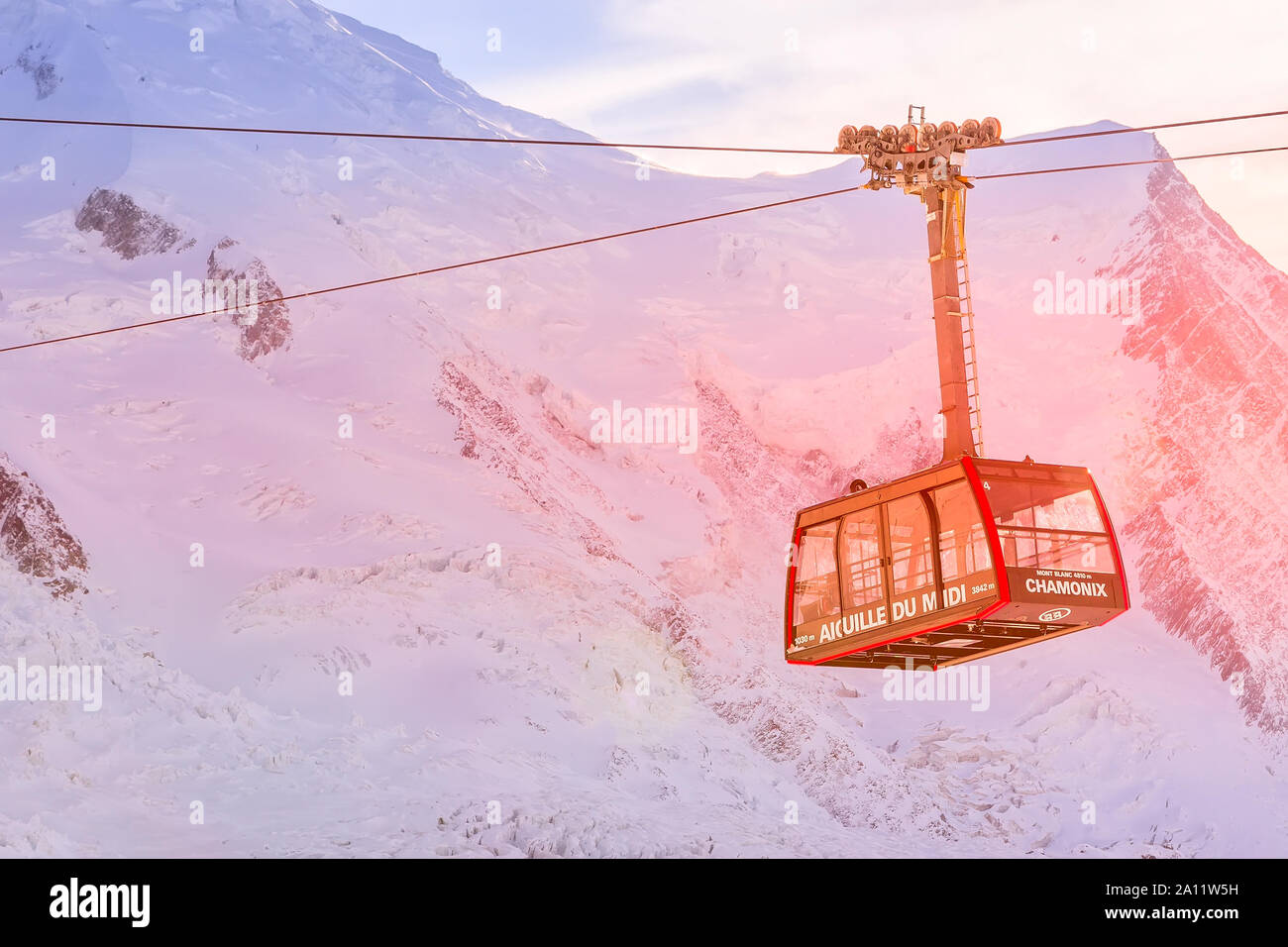 Chamonix Mont Blanc, Frankreich - Januar, 28, 2015: Seilbahn von Chamonix auf den Gipfel der Aiguille du Midi und rosa Sonnenuntergang Schnee Berge Panorama Stockfoto