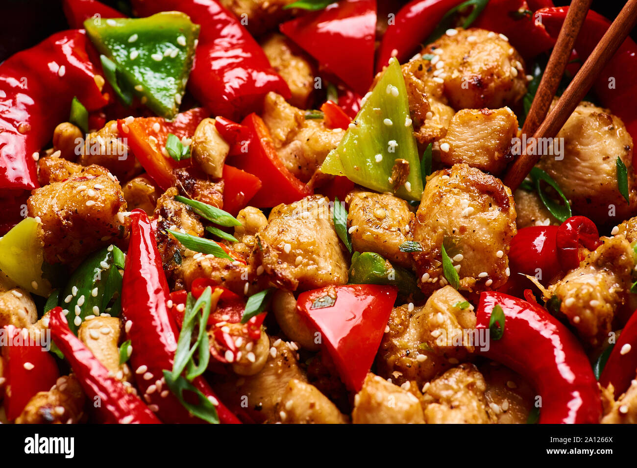 Schezwan Huhn oder Dragon Huhn an der schwarzen Schiefer Hintergrund. Szechuan Chicken ist beliebt indo-chinesischen würzigen Gericht mit Paprika, Huhn und Gemüse Stockfoto