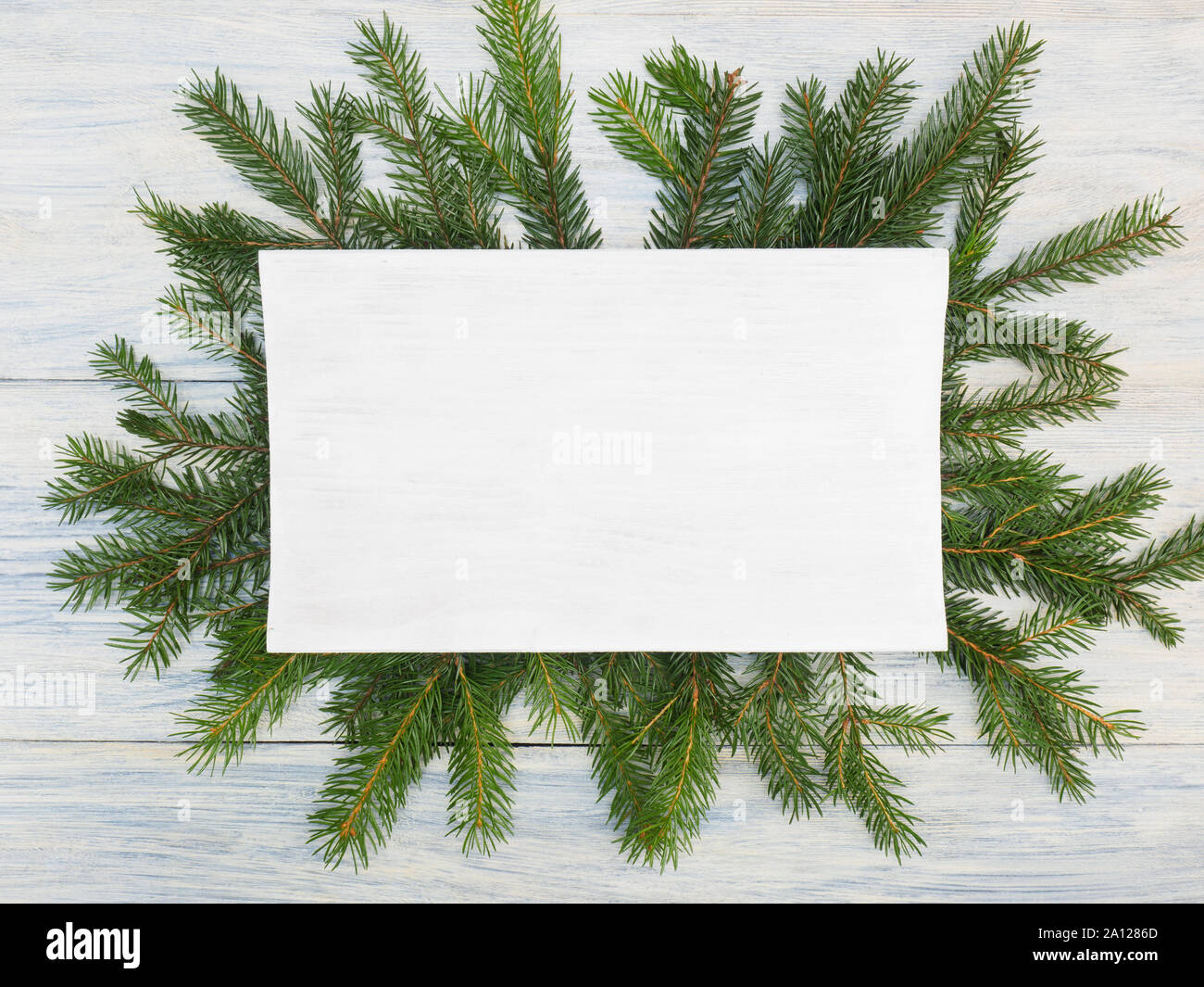 Fir Tree Branch mit Typenschild auf weißem Holz- Hintergrund. Winterurlaub Konzept Stockfoto