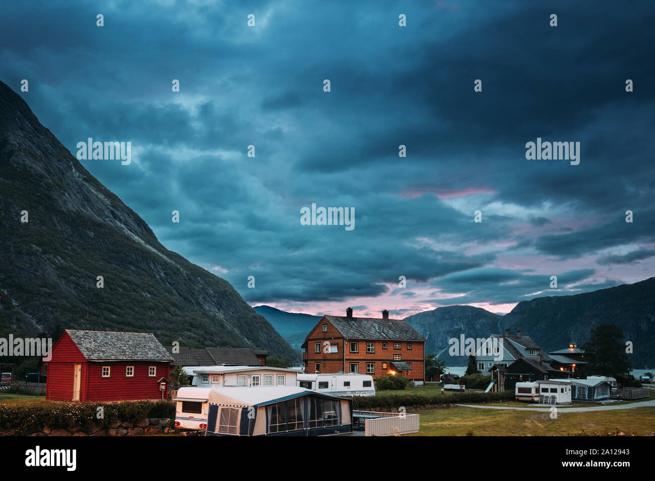 Eidfjord, Hordaland County, Hardanger Region, Hardangerfjord, Norwegen. Caravan Reisemobil Autos parken in der Nähe von Alte Holzhäuser in der norwegischen Landschaft. Stockfoto