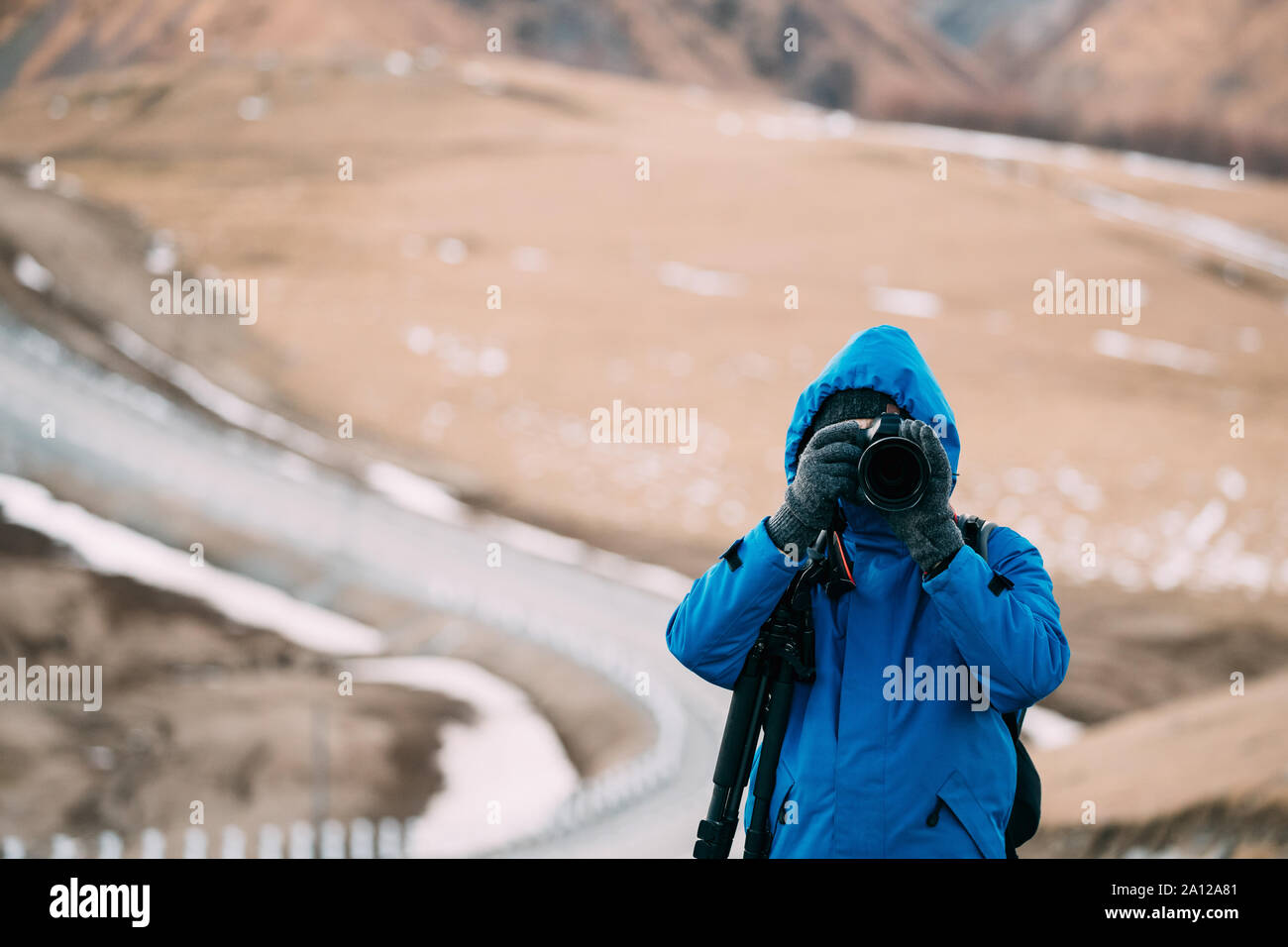 Junge Erwachsene kaukasischen Mann Touristen Backpacker Reisender Fotograf Fotos Fotos in wunderschönen Berge Landschaft im frühen Winter. Stockfoto