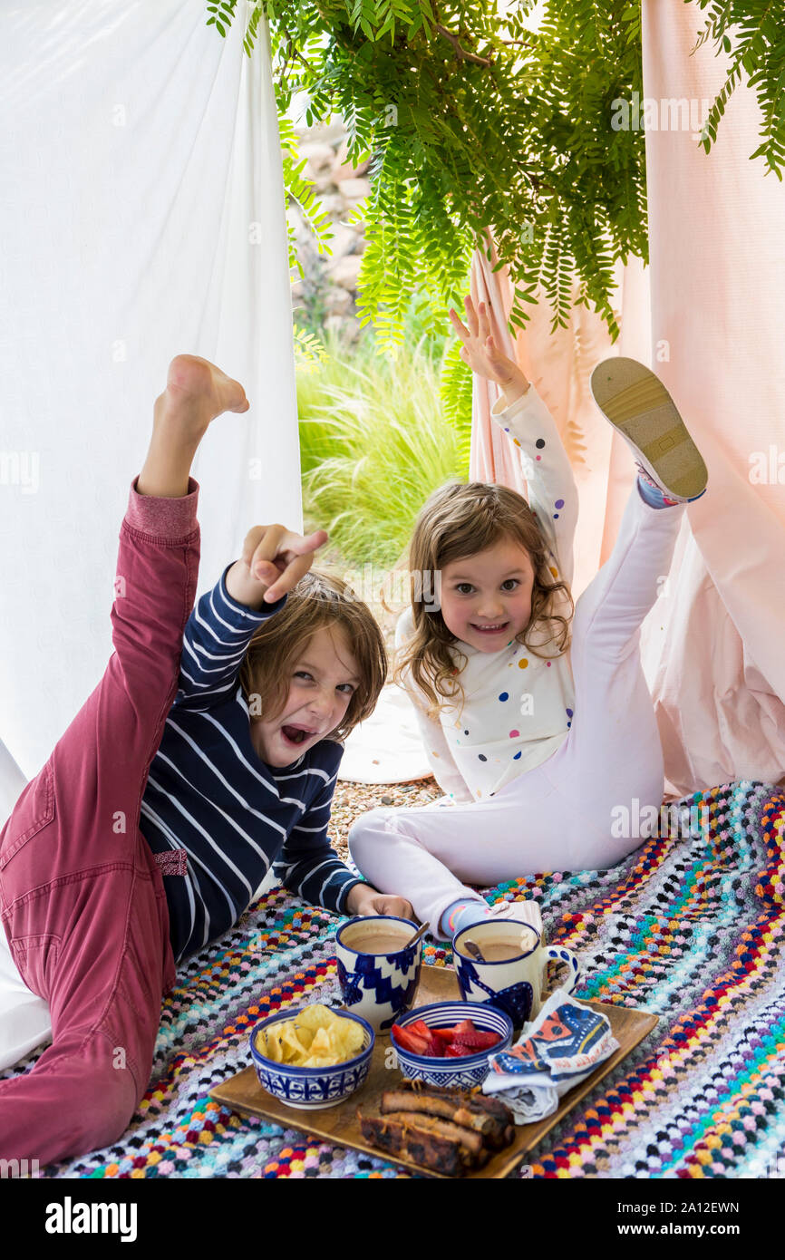 Jungen und Mädchen spielen im Freien improvisierten Zelt Stockfoto