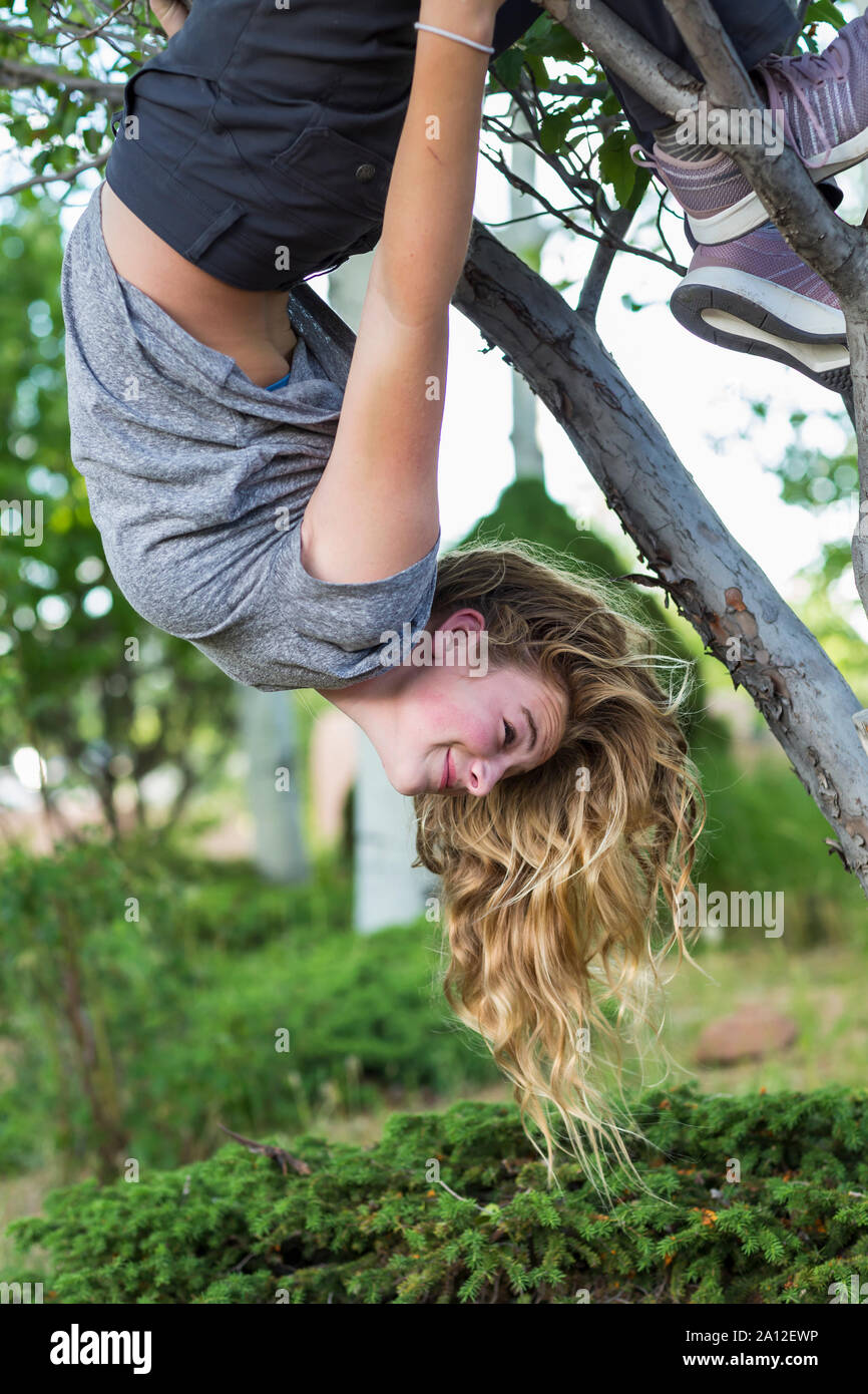 Der 13 Jahre alte Mädchen hing kopfüber vom Baum Stockfoto