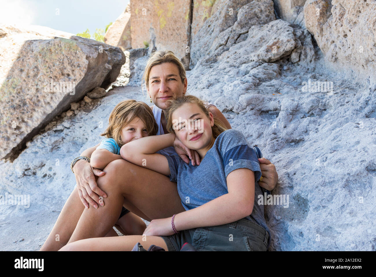 Mutter und ihre Kinder sitzen auf den Felsen, Tsankawi Ruinen, NM Stockfoto