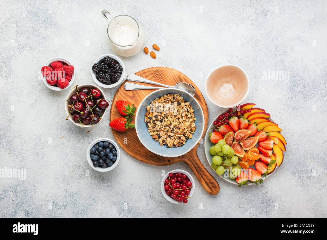 Gluten und Getreide frei paleo Müsli oder Müsli aus Nüssen. Obst Beeren Platter, Erdbeeren Heidelbeeren Himbeeren pfirsich Feigen rote Johannisbeere, Mandelmilch, Ansicht von oben, selektiver Fokus Stockfoto