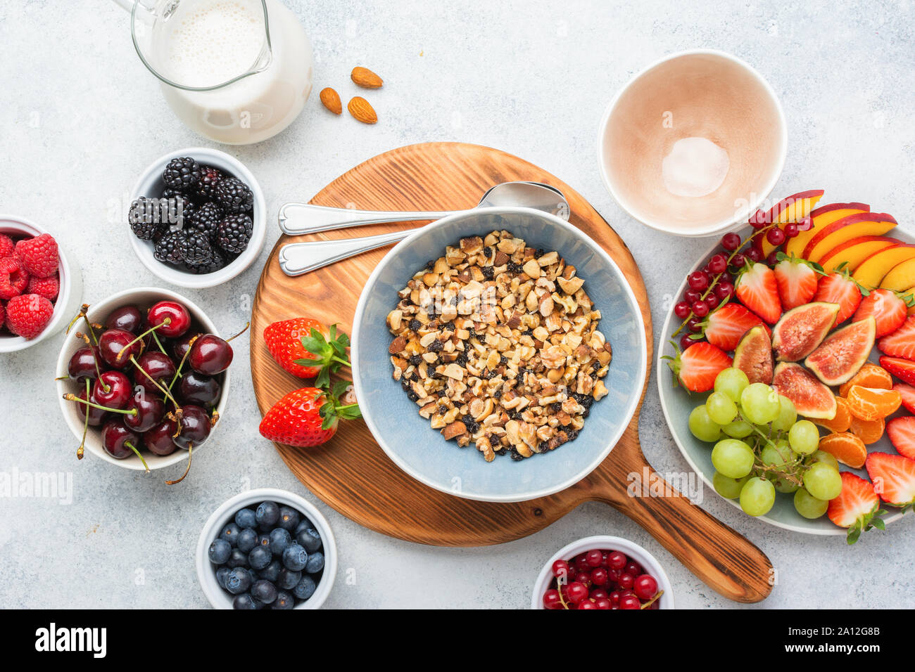 Glutenfreie und Getreide frei paleo Müsli oder Müsli aus Nüssen gemacht. Obst Beeren Platter, Erdbeeren Heidelbeeren Himbeeren pfirsich Feigen rote Johannisbeere, Ansicht von oben, selektiver Fokus Stockfoto