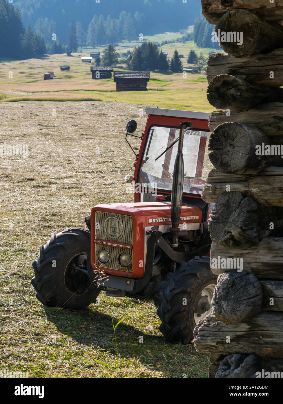 Traktor neben einer Scheune, Detail der Heuernte auf der Tschey Wiesen in Pfunds Stockfoto