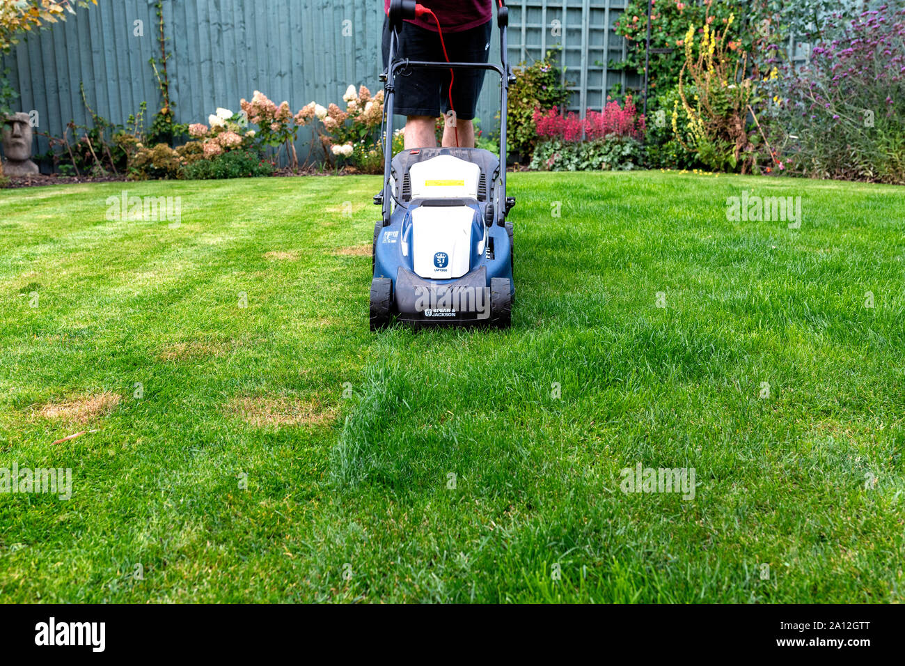 Man mäht seinen Rasen mit einem Speer und Jackson elektrische Rasenmäher (nach vorn ein ( Stockfoto