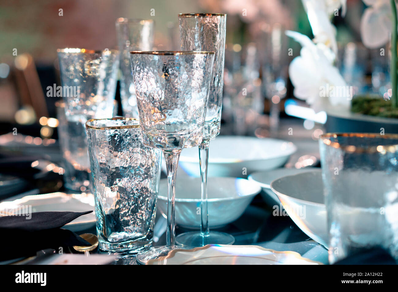 Luxus Catering und Service. Hochzeit oder Jubiläum. Bankett Tisch serviert mit Blumen und Gläser für Wein oder Champagner. Stockfoto