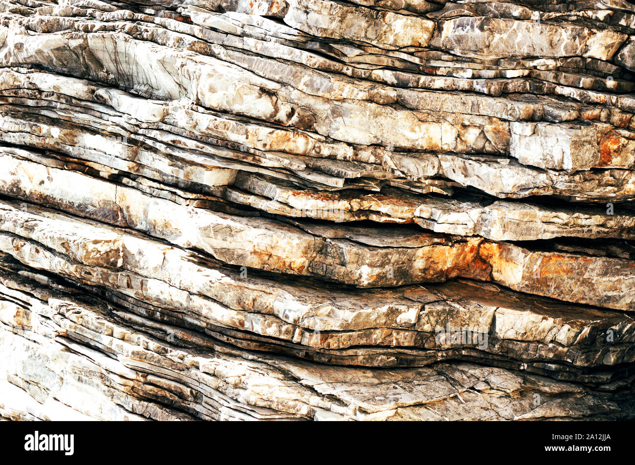 Strukturierte Schichten und Risse in den Felsen auf einer Klippe. Natur abstrakt Hintergrund. Stockfoto