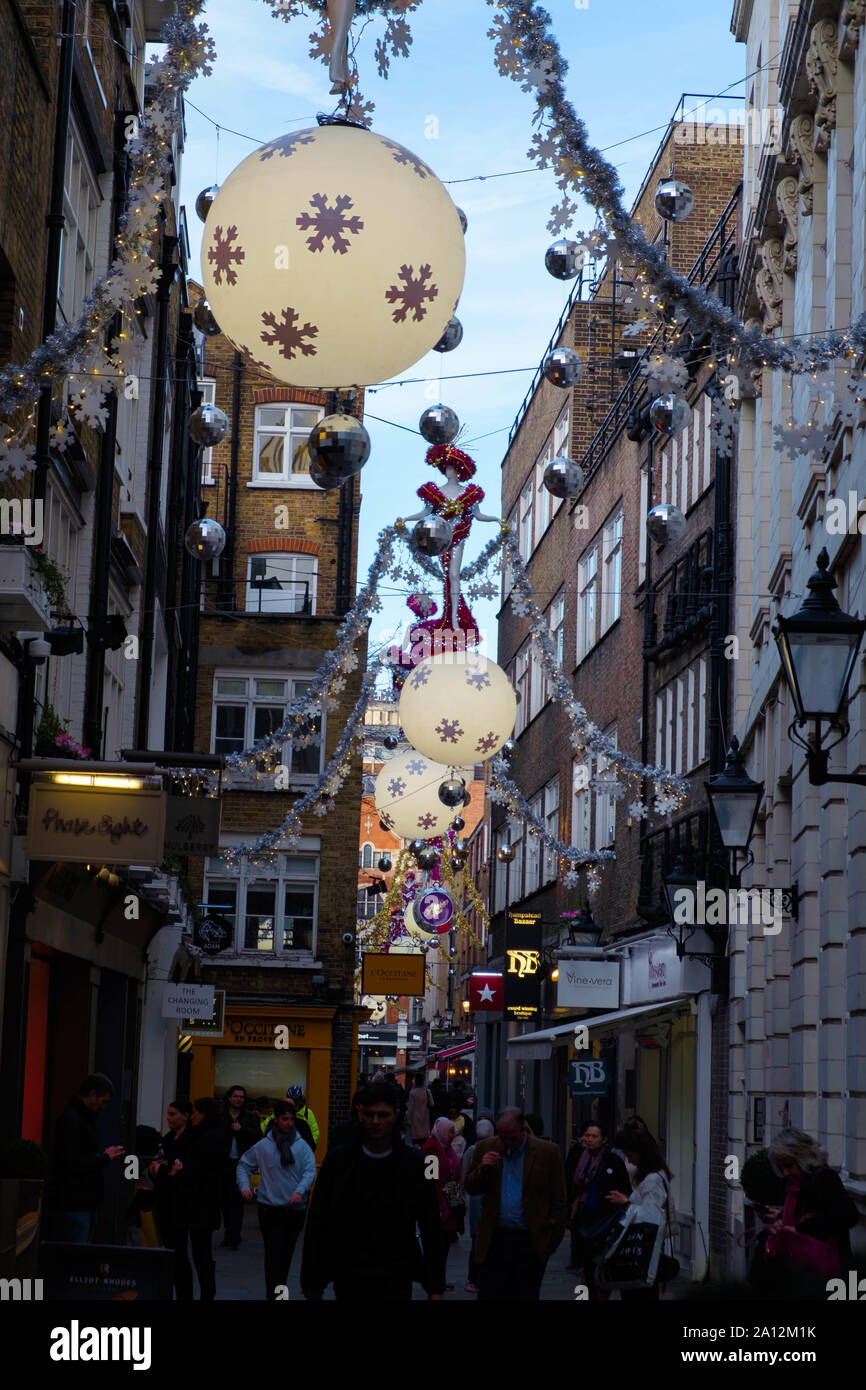 Touristen und Einheimische, die das Londoner Shop & knüpfen am St. Christopher's Place, die Fußgängerzone mit den Street, Oxford Street London zur Weihnachtszeit. Stockfoto