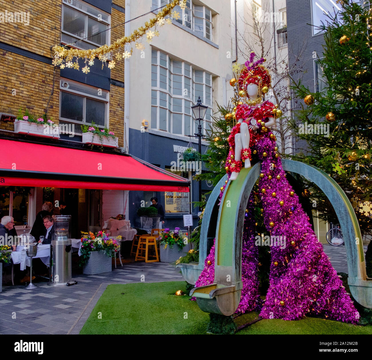 Leute genießen Essen & Trinken bei Sofra türkisches Restaurant, St. Christopher's Place, high-end Shopping Street in Central London, in der Weihnachtszeit. Stockfoto