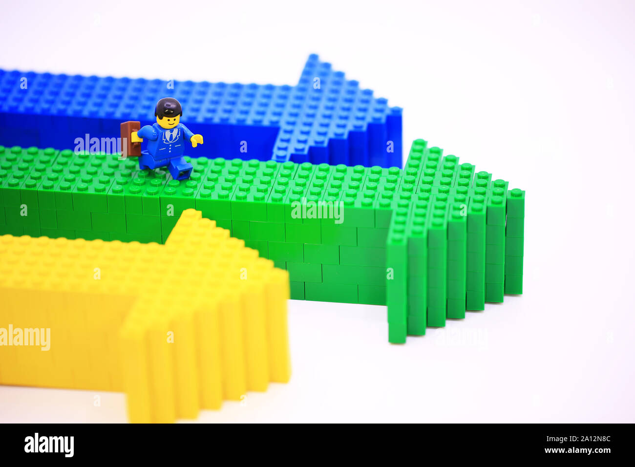 Er Lego mini Zeichen ist zu Fuß auf den Pfeil. Lego Miniatur sind die erfolgreiche Linie in Lego Produkte. Stockfoto