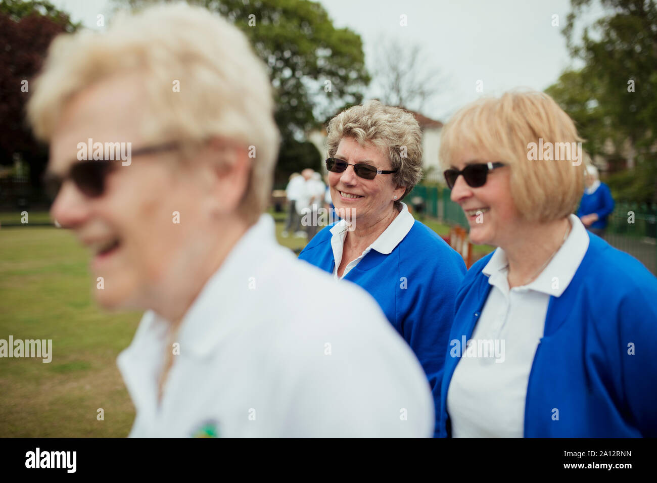 Eine Seitenansicht geschossen von einer Gruppe von älteren Frauen an einem bowling green lächelnd. Stockfoto
