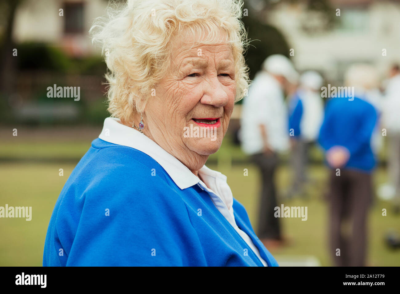 Eine Nahaufnahme von einer älteren Frau lächelnd, von der Kamera entfernt. Stockfoto